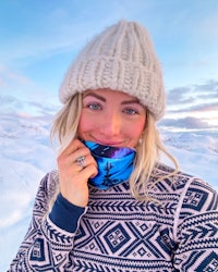 a woman wearing a blue scarf and hat in the snow