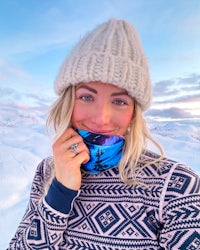 a woman wearing a blue scarf and hat in the snow